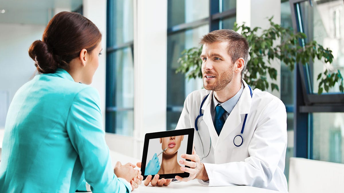 A male physician talking to female patient on plastic surgery